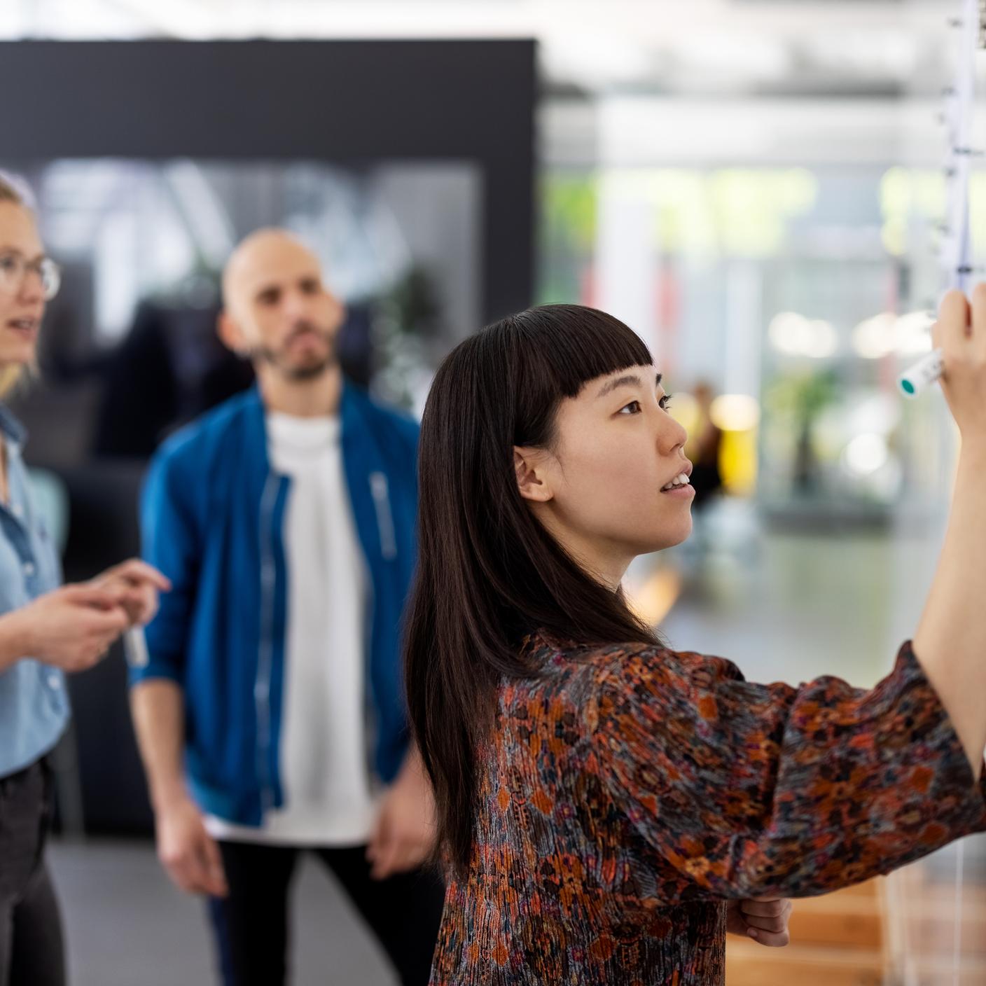 Une femme écrivant sur un tableau blanc debout lors d'une session d'audit