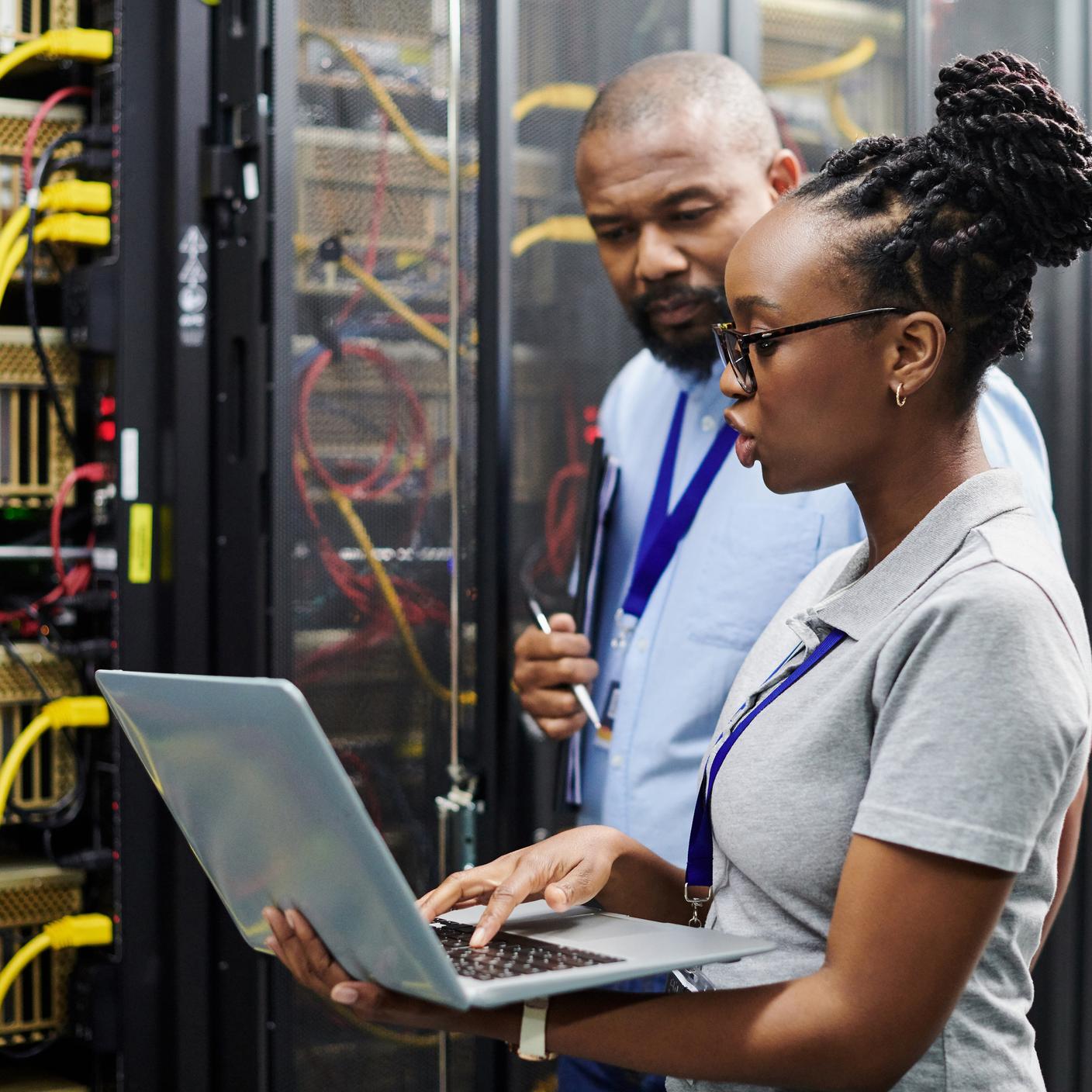 Shot of two technicians working together on a laptop in a server room. Developing an action plan for improved operations