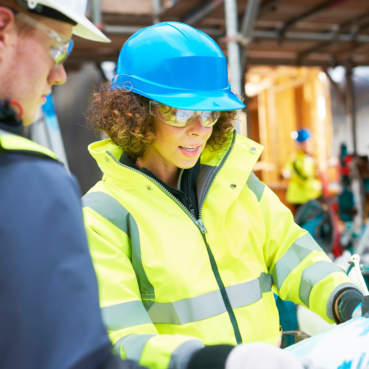 a female construction worker stands on a building site