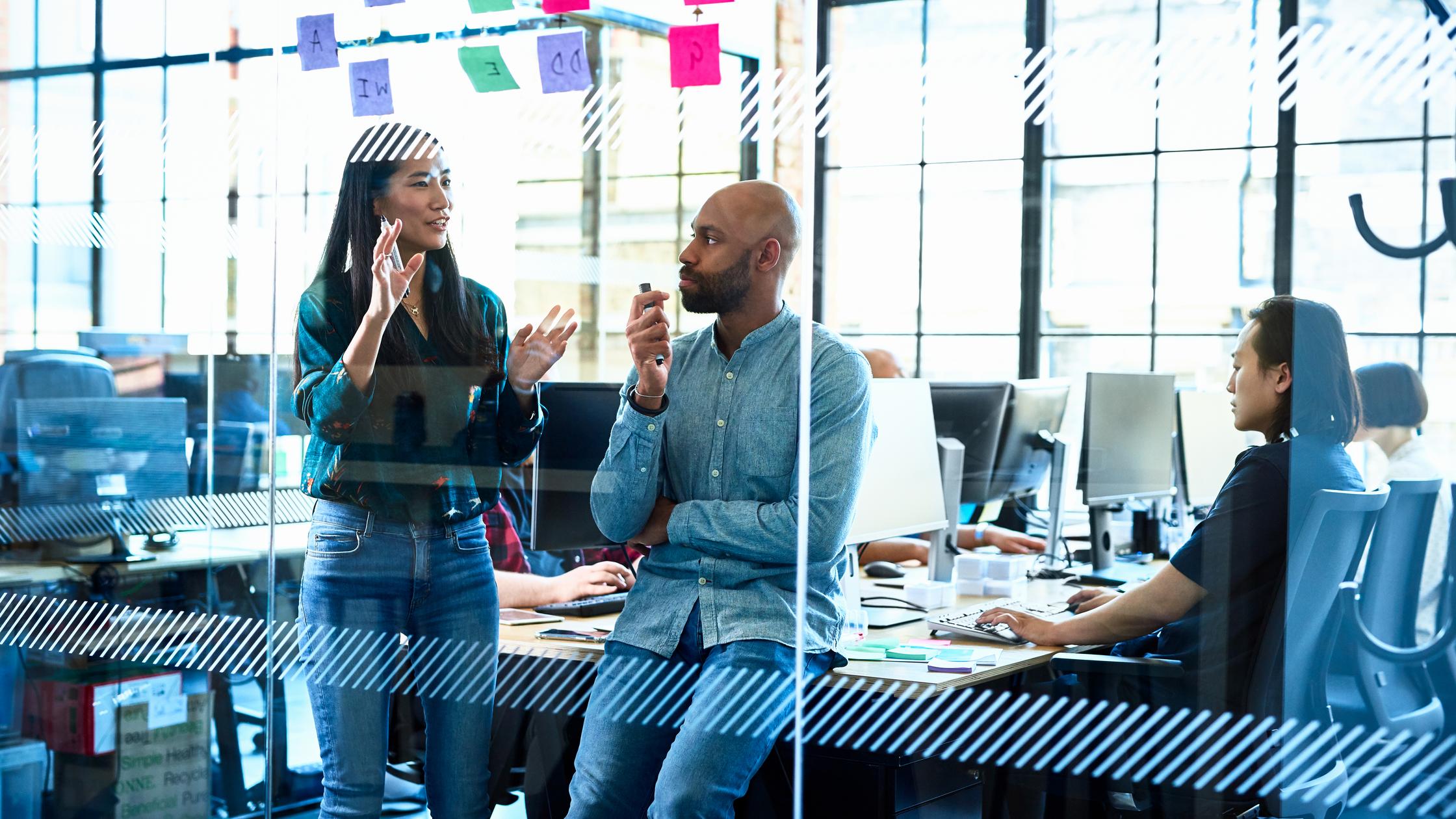 Quality Management - Businesswoman standing by male manager in office