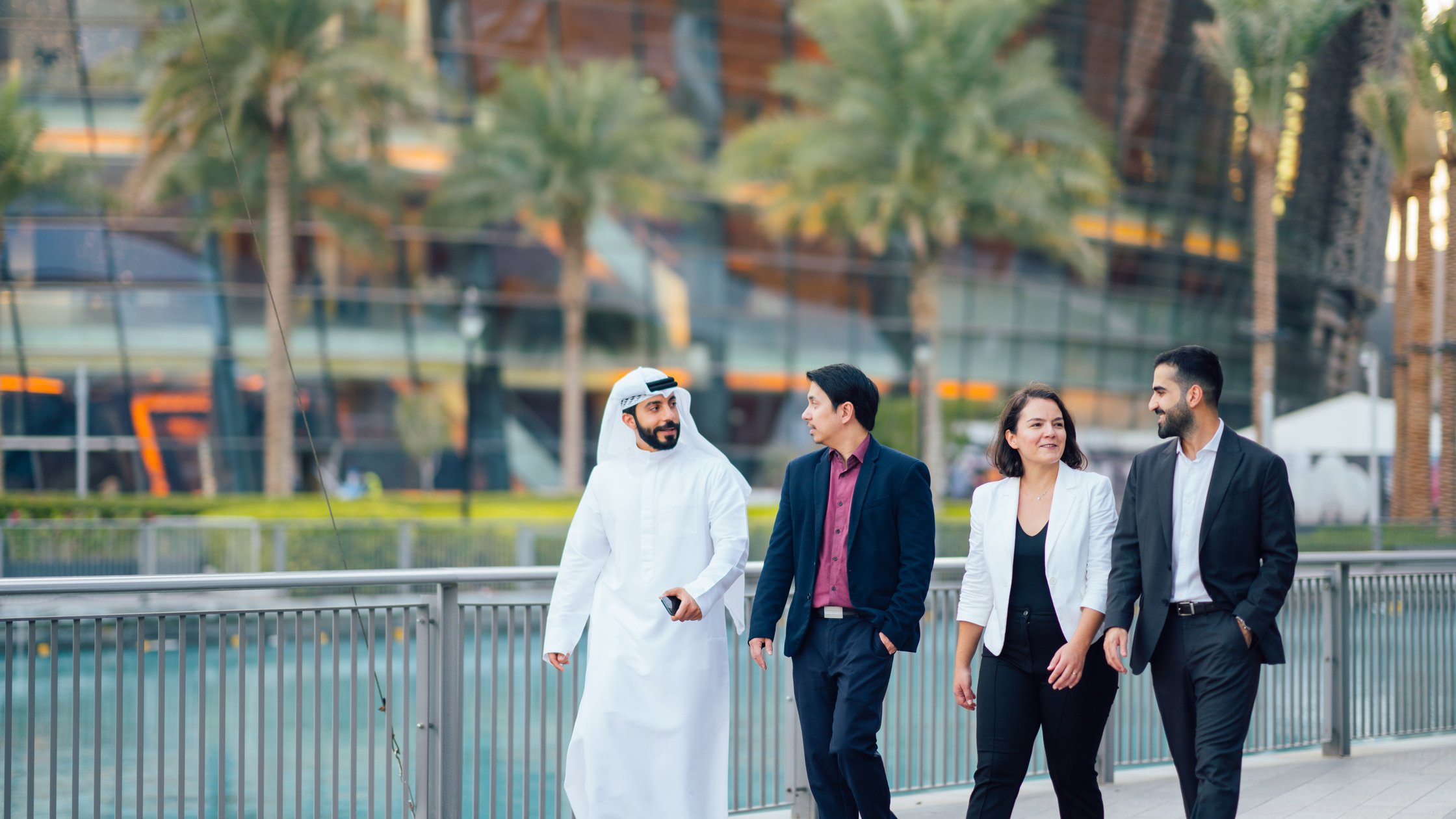 Eine Gruppe von Personen, die sich bei einem Spaziergang über geschäftliche Angelegenheiten unterhält