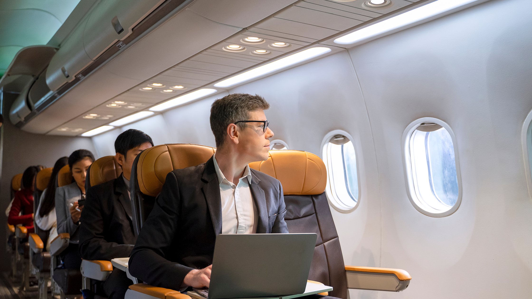 Passengers are sitting in the commercial plane.